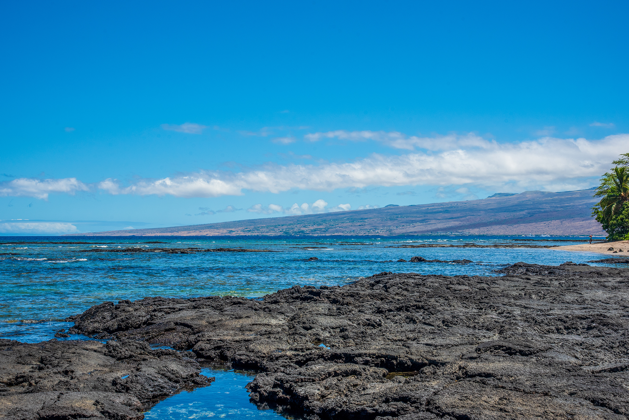 Puako coastline with lava rocks and ocean views.