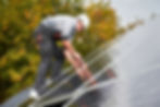 Worker installing solar panels on a roof