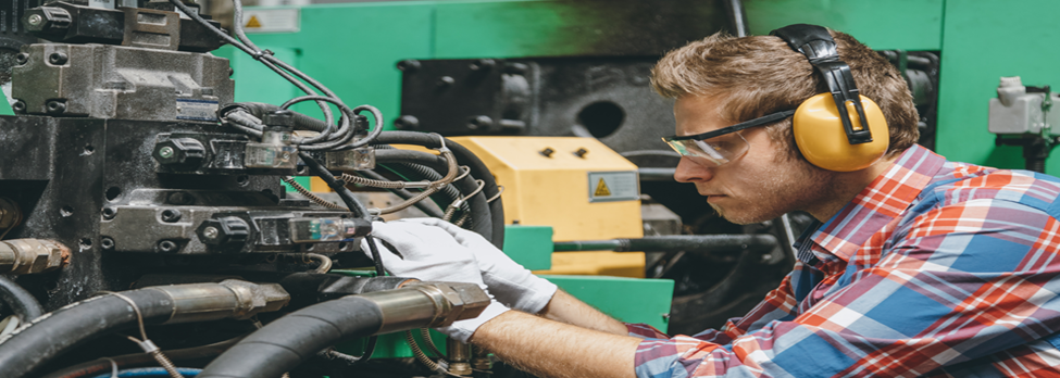 Man doing service inspection work on an extruder.