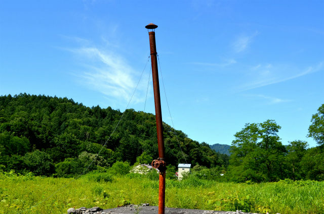 周囲に施設跡が無く、ただただ蒼い夏空と茂った草木に取り囲まれる不自然で孤独な錆色