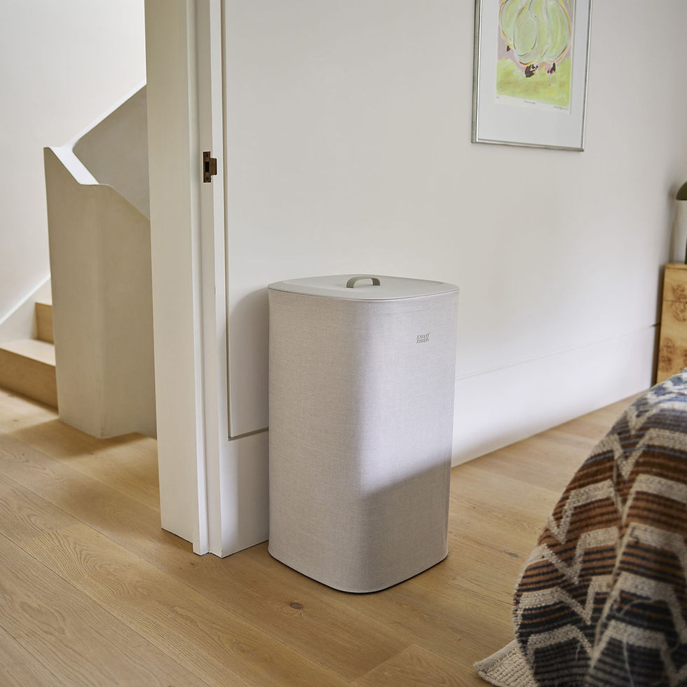 Op de afbeelding zie je de ecru Joseph Joseph Tota One wasmand van 60 liter in een slaapkamer naast een open deur