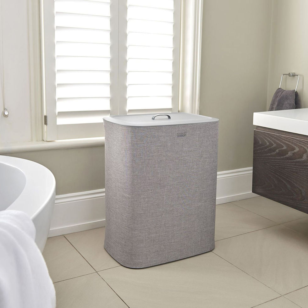 Grijze Joseph Joseph Tota wasmand met twee sorteervakken in badkamer met raam en witte shutters