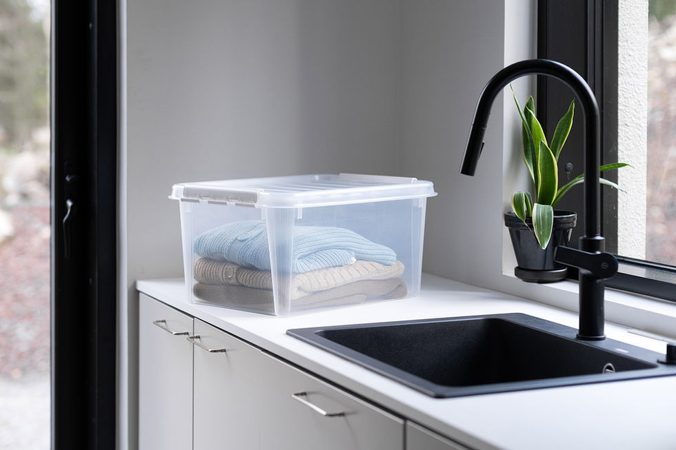 Orthex SmartStore Classic 31 opbergbox met witte clips op aanrecht, gevuld met gewassen kleding in moderne wasruimte