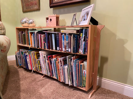 Ash suspended bookcase with handcut dovetail sides and sycamore legs and supports. Finished in shellac.