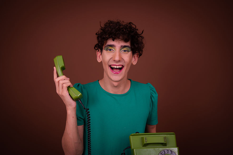Funny drag queen posing in the studio on a brown background with a vintage phone..jpg