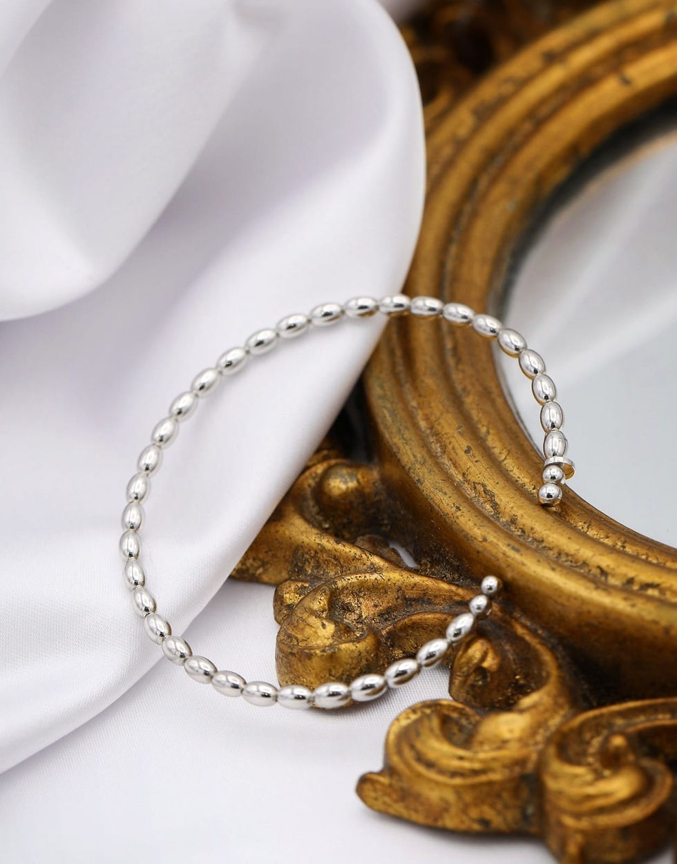 Miniatura: Pulseira rígida em prata branca com motivos ovais, sobre espelho