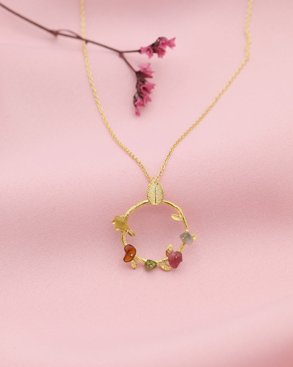 Miniatura: Fio em prata dourada com pendente - coroa de turmalinas coloridas ao natural, vista em fundo cetim rosa.