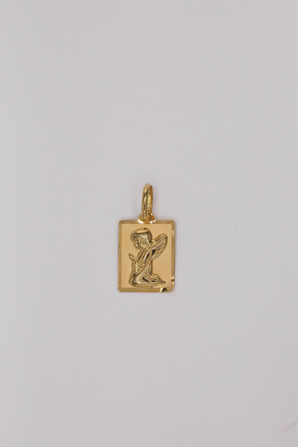 Medalha retangular em ouro amarelo com anjo da guarda em oração.