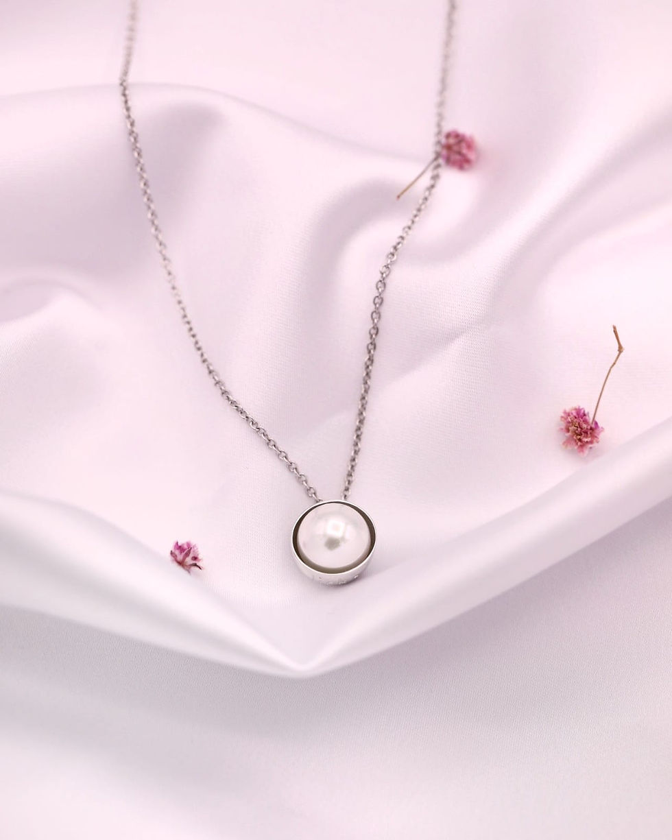 Miniatura: Fio em prata com pérola sobre fundo de cetim