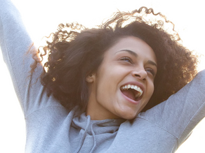 a woman jumping in the air shouting with her hands up