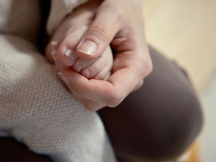 Main d’un parent tenant la main d’un jeune enfant, symbole du lien parental