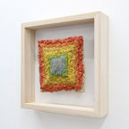 Colorful wall sculpture, modeled layer by layer from a self-made wood pulp, framed in a larch wood frame.