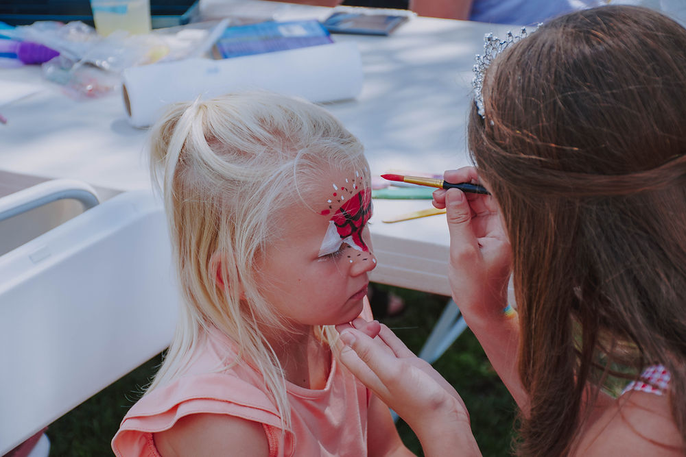 A little girl getting her face painted at Cookin' on Kampeska