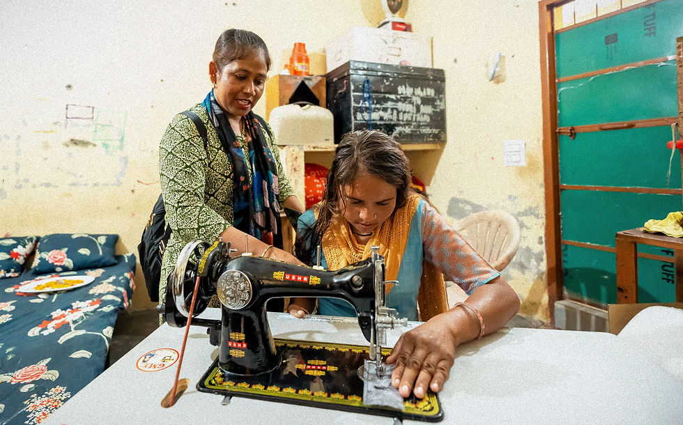 Manju teaches Rinku how to sew.