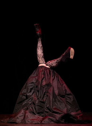 burlesque performer. legs in the air. comedy burlesque. fishnet tights. gothic model. alternative model