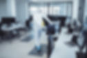 Office disinfection during COVID-19 pandemic. Man in protective suit and face mask sprayin