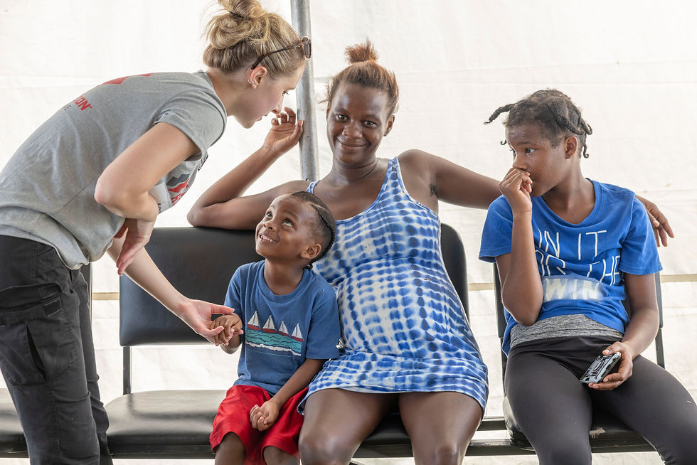 A paramedic tends to a young family. Savanna La Mar, Westmoreland