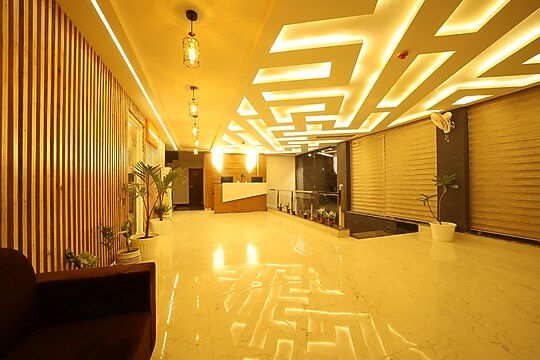 Modern boutique hotel lobby with bright lighting, stylish ceiling, reception.