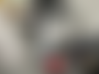 Office setting with a printer, calculator, and black device on a table. Concrete floor and wall, metal shelves in the background.