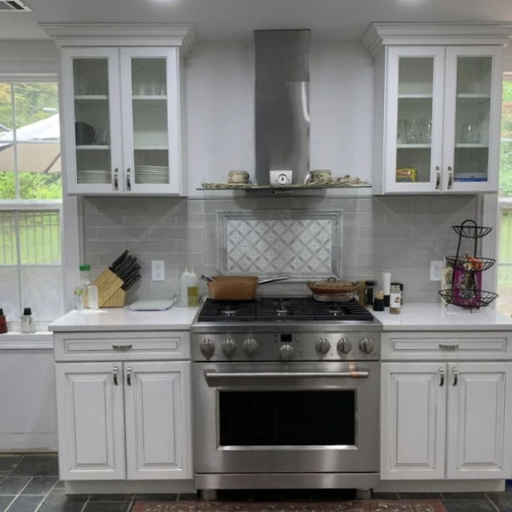 a remodeled kitchen with white and silver accents