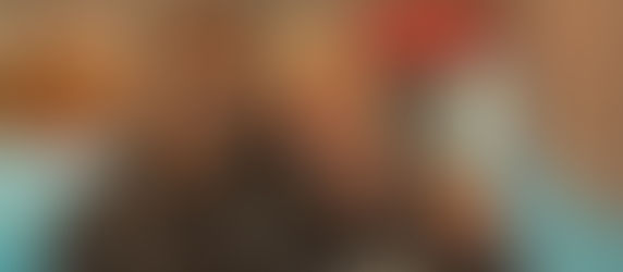 Två tränare står tillsammans och ler in i kameran, och i bakgrunden syns en gymnastiksal.