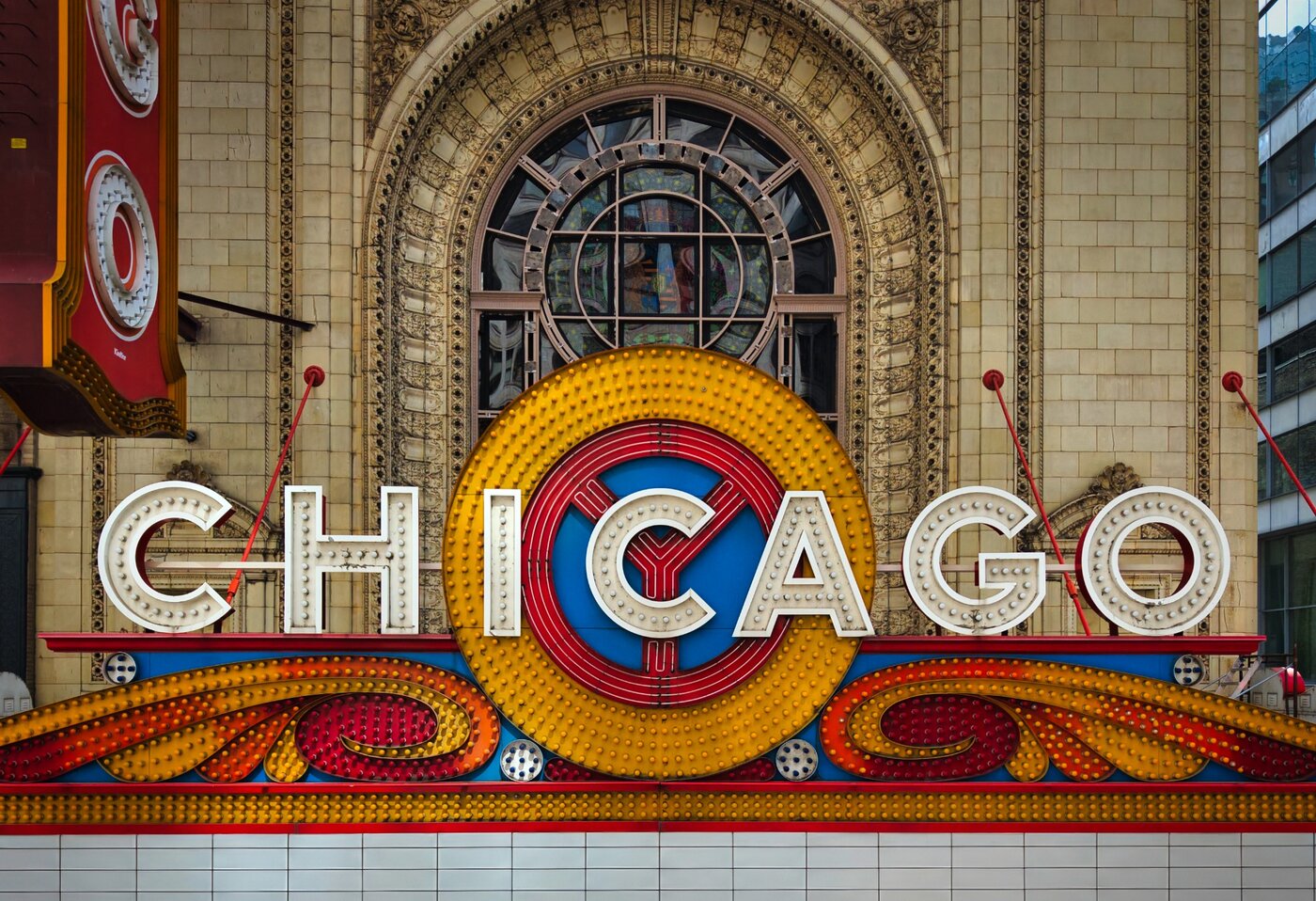 Chicago Theatre Overture Close view of the Chicago Theatre marquee and ornate arched window.