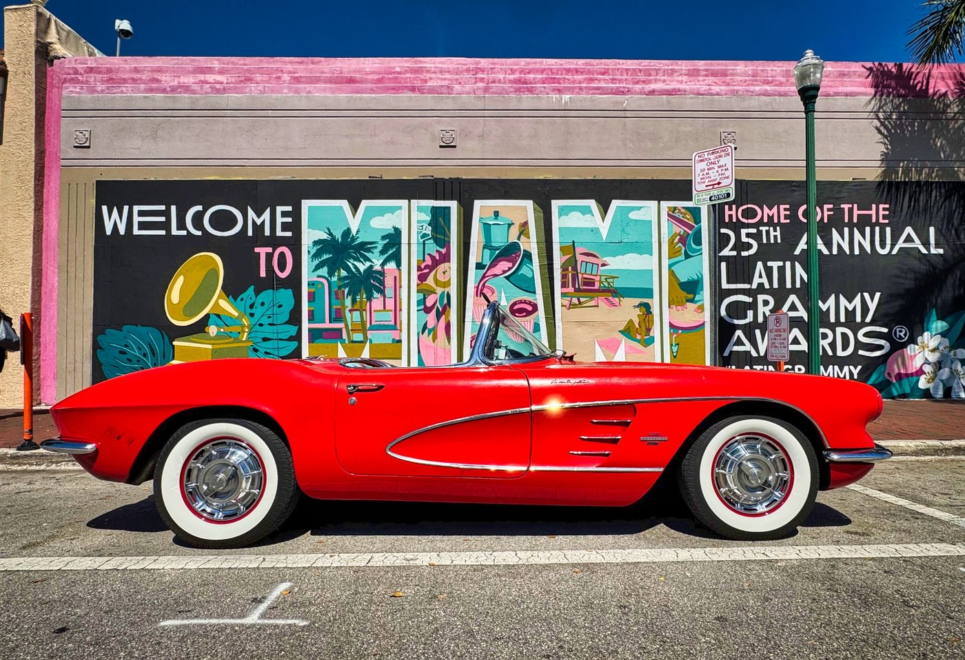 Little Havana CLASSIC Red vintage convertible parked in front of a colorful street mural.