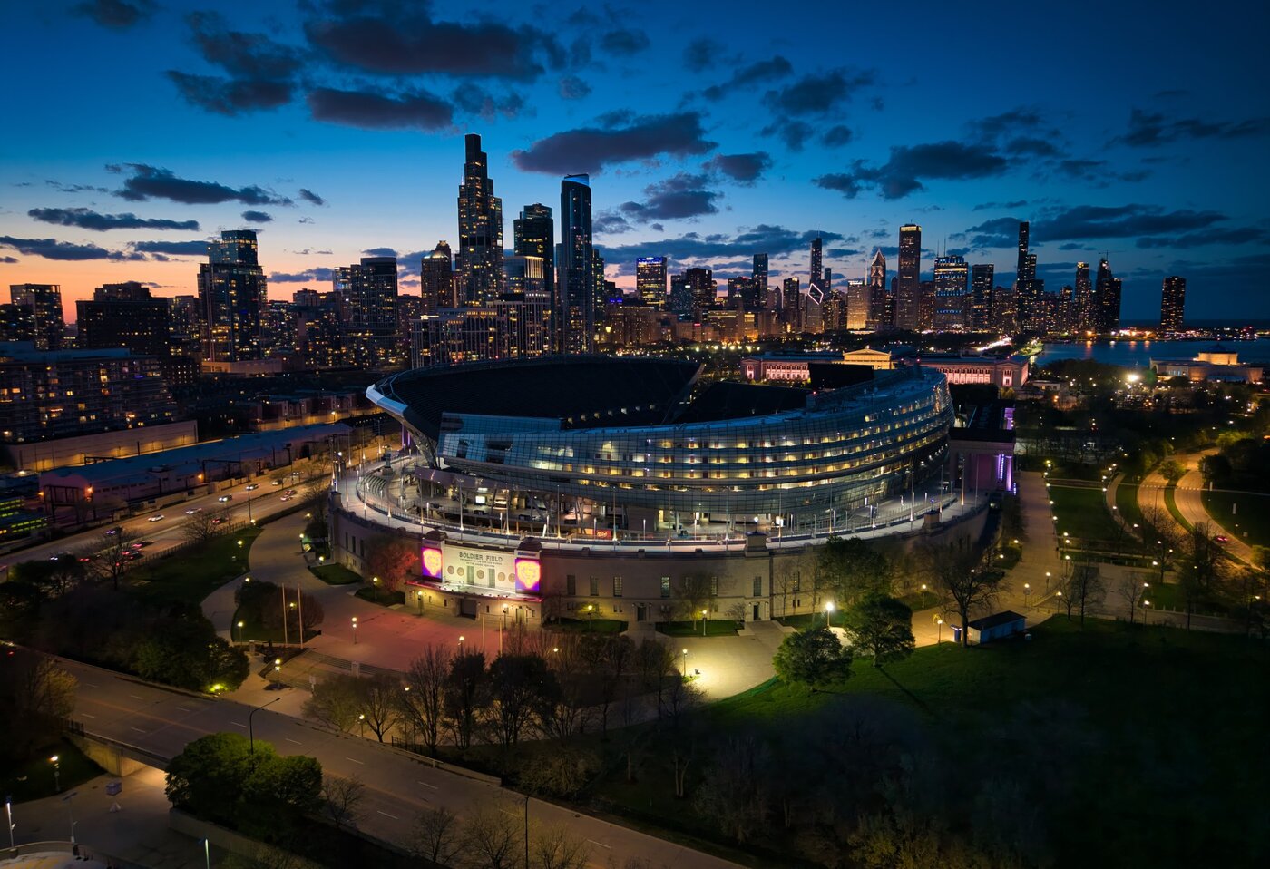 Soldier Field at Blue Hour Elevated view of illuminated Soldier Field with Chicago skyscrapers and a blue evening sky.