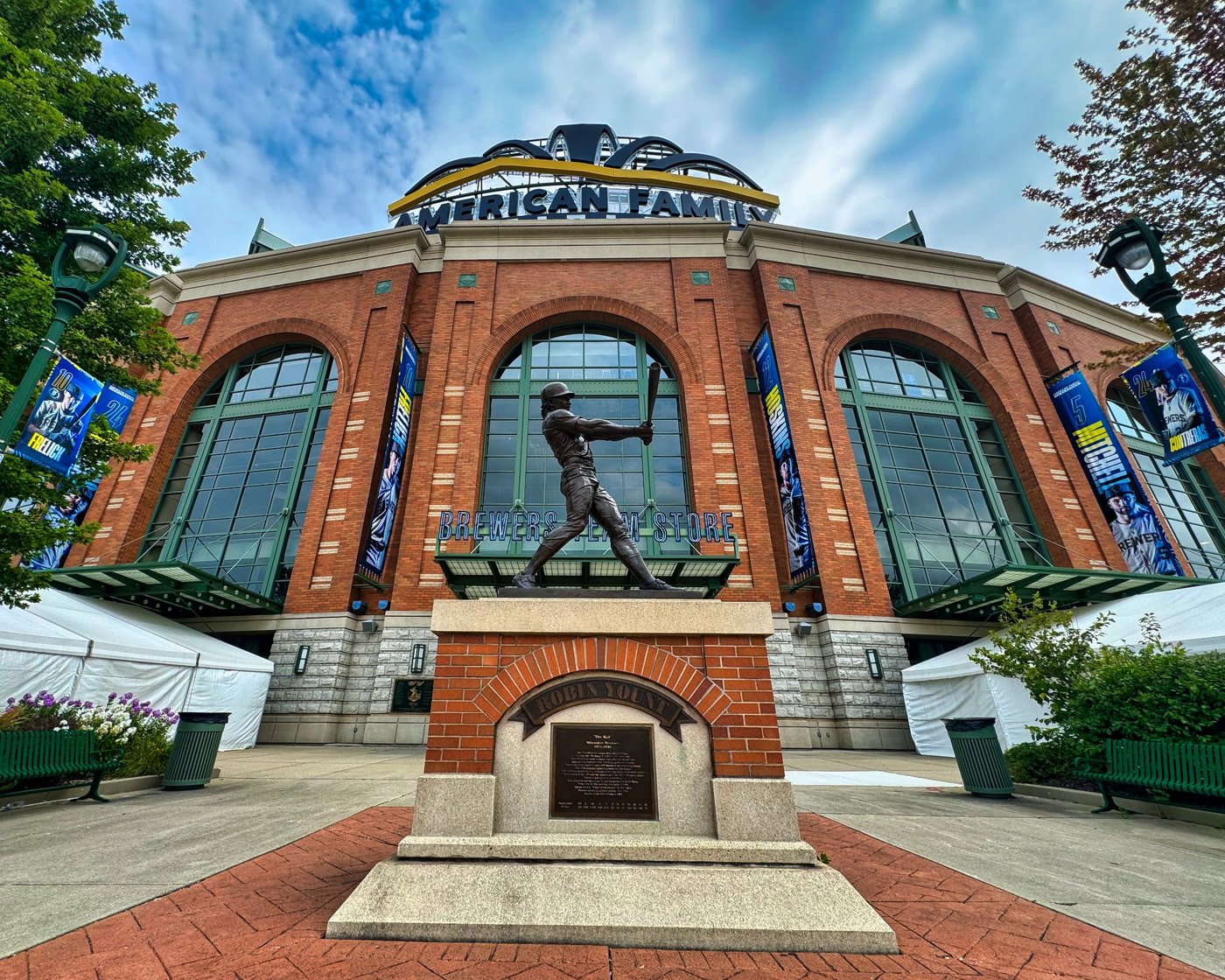 Bronze baseball batter statue outside the brick facade of American Family Field.