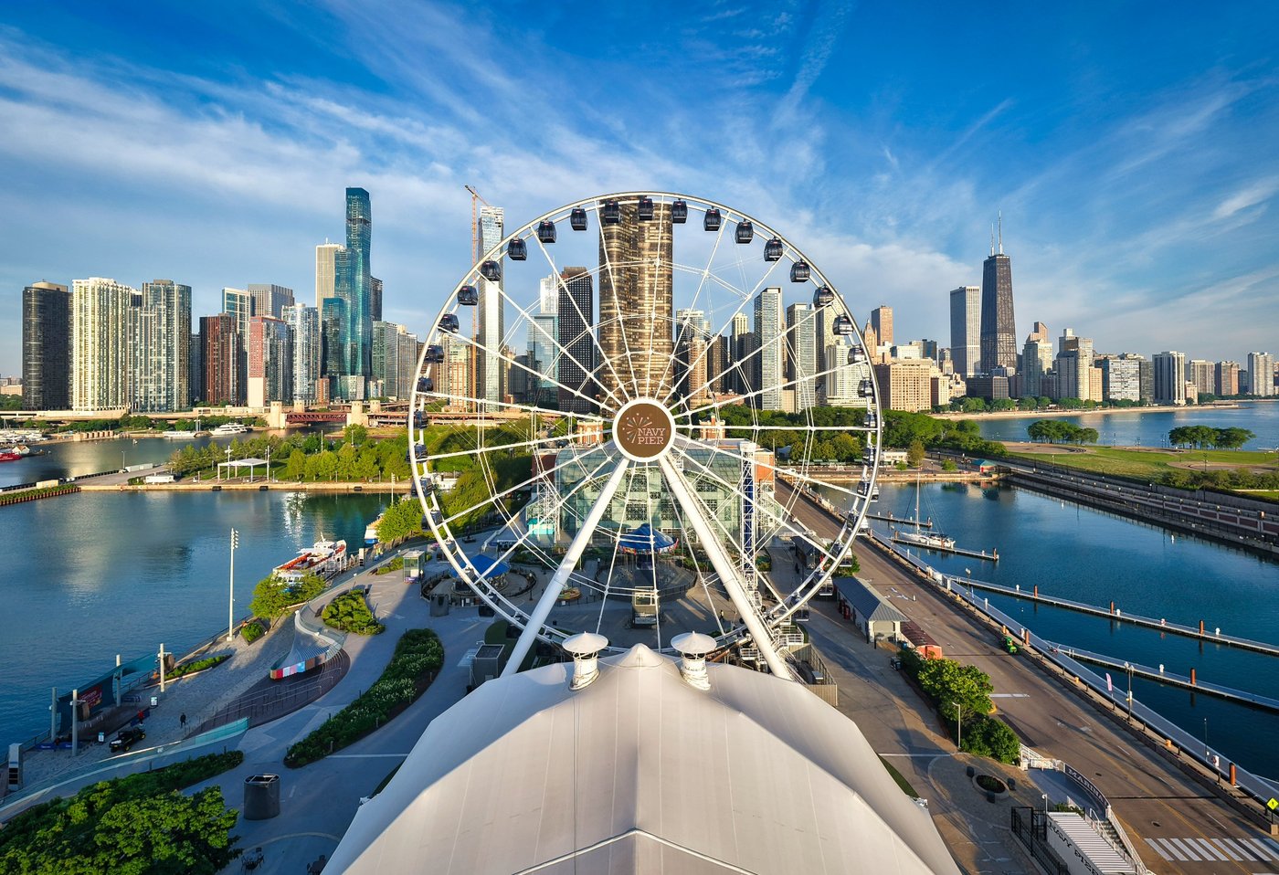 Wheel Above the Water Navy Pier Ferris wheel above a white roof with Chicago skyline and streaked clouds behind.