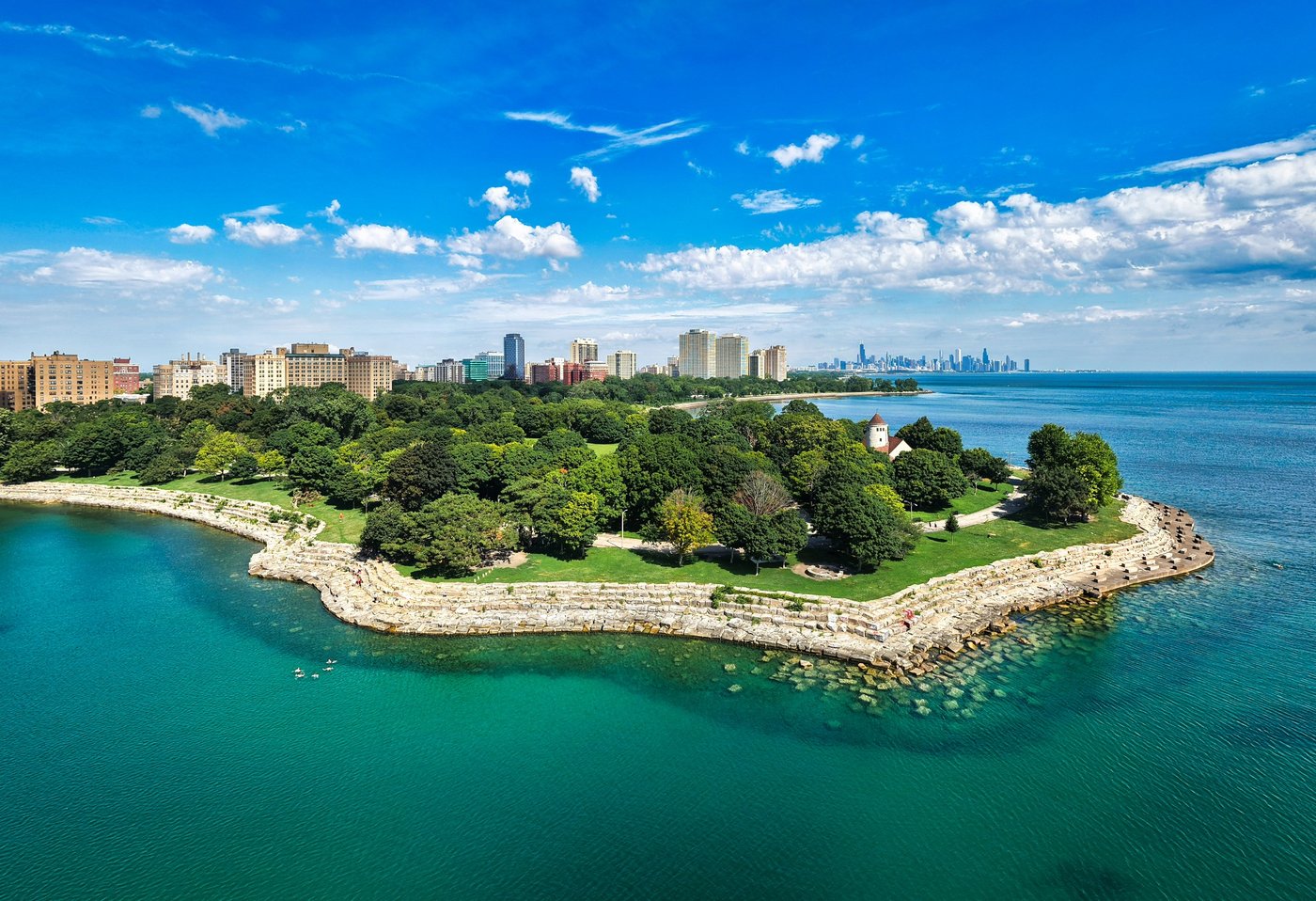 At Promontory Point Tree-covered Chicago lakefront point edged by pale rocks and clear green water.