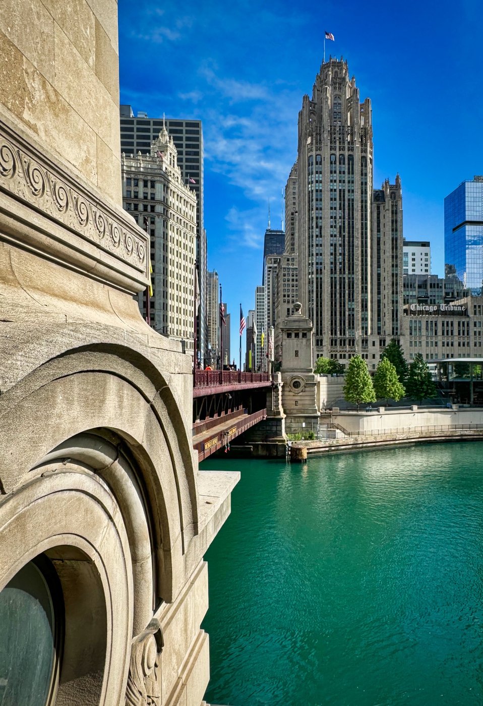 Tribune Tower Tribute Tribune Tower across the turquoise Chicago River beside a close carved stone facade.