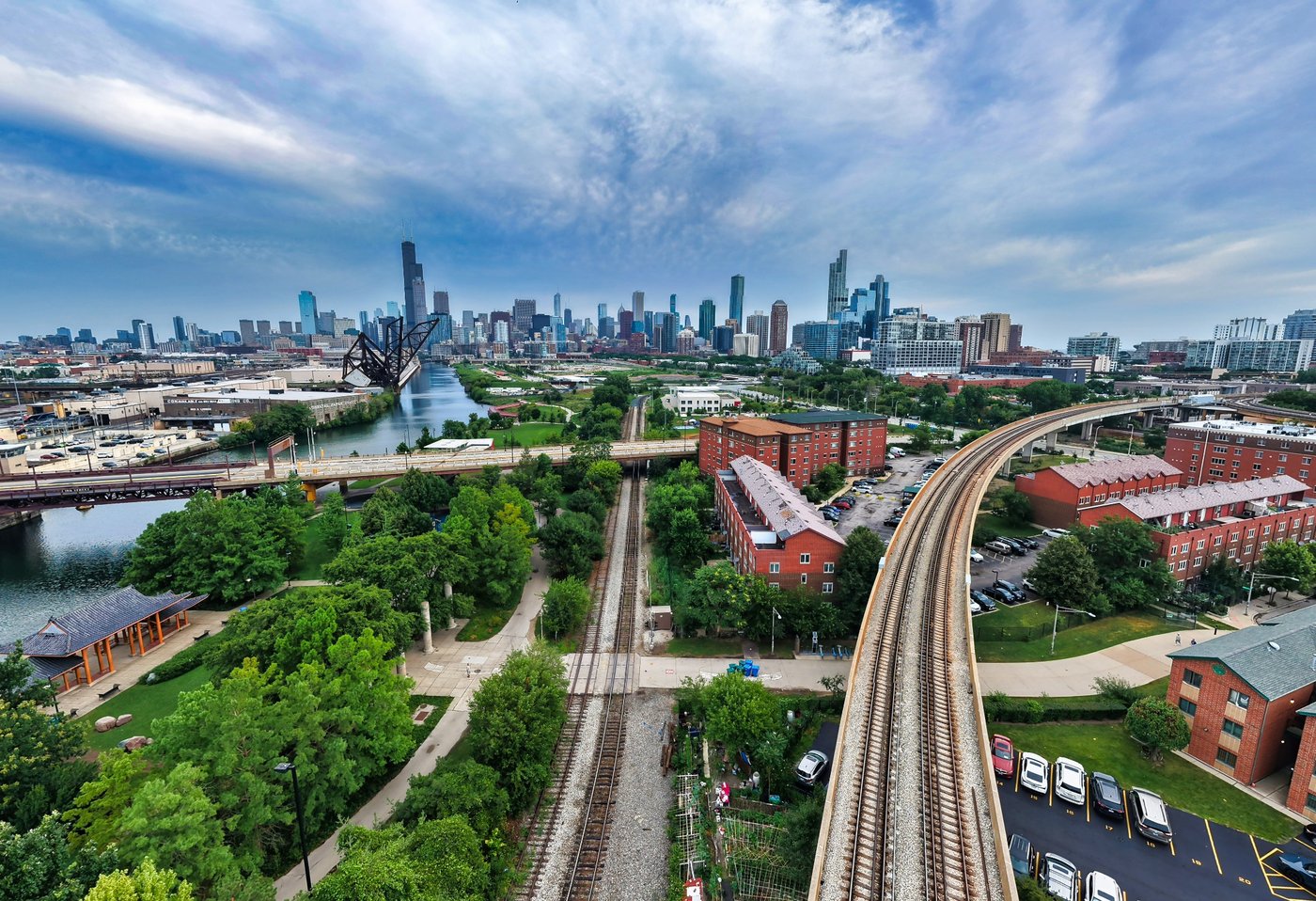 Rails Toward the Skyline Railway tracks curving through Chicago beside brick buildings and green space toward downtown.