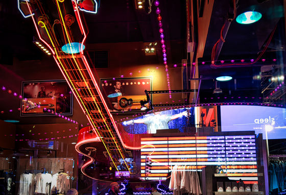 Illuminated guitar and colorful reflected lights inside the Hard Rock Cafe in Times Square.
