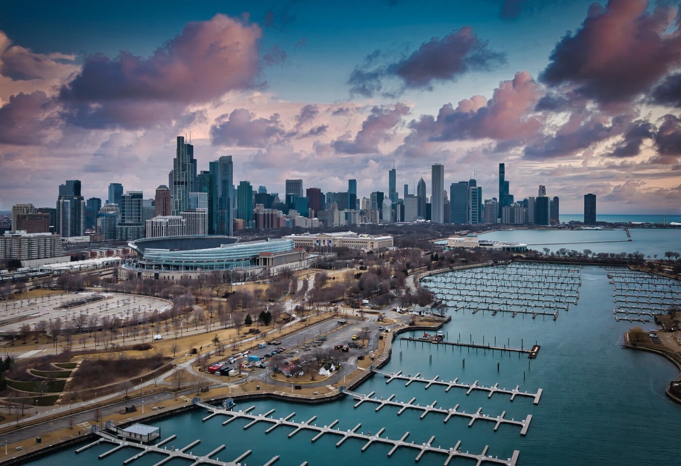 Unoccupied Harbor Empty marina slips beneath a skyline and pink-tinged clouds.