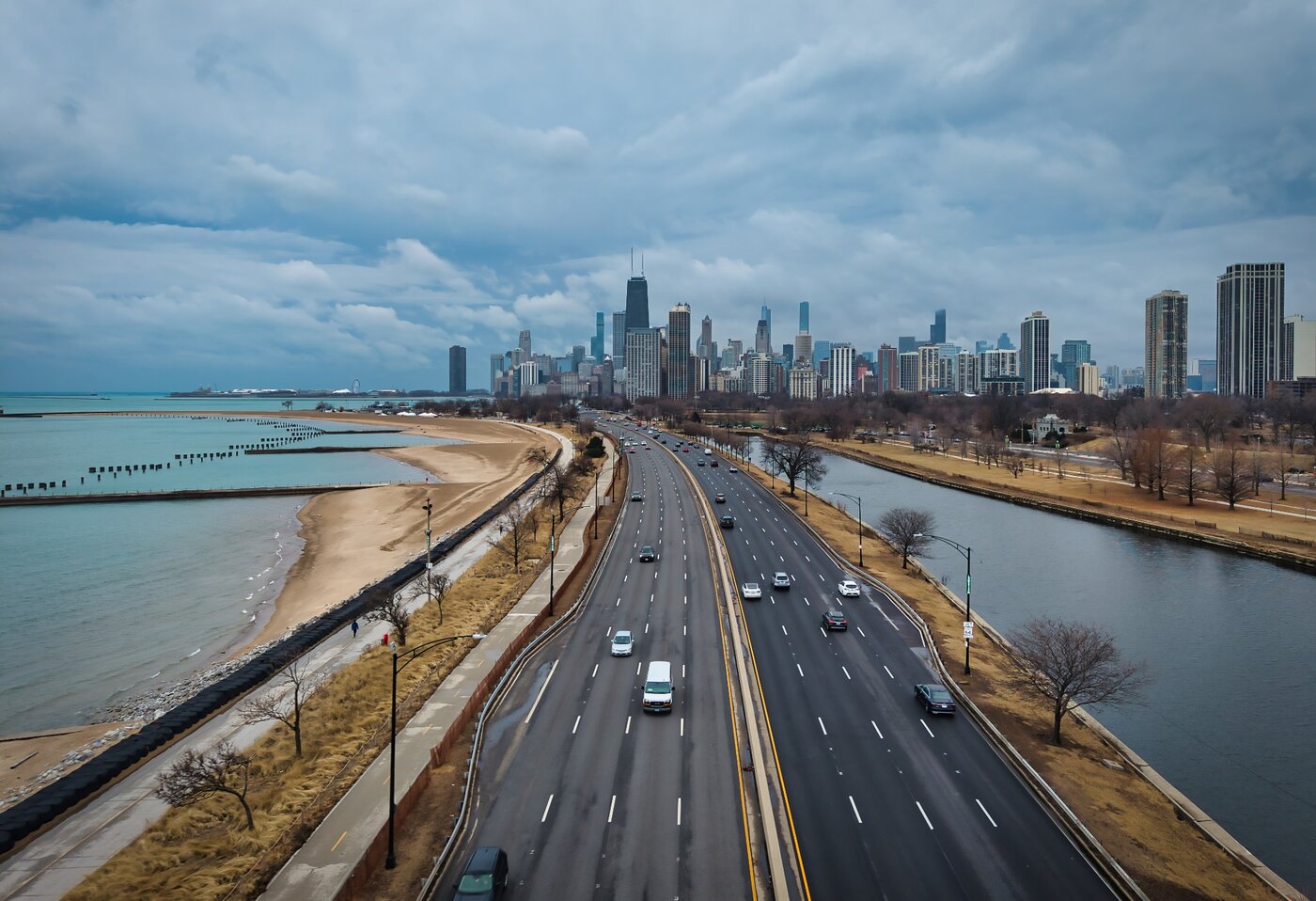 Lake Shore Flow Shoreline highway carrying traffic toward a skyline under overcast skies.