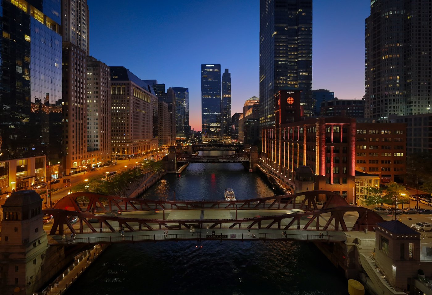 Blue Hour on the Chicago River Chicago River at dusk with successive bridges and illuminated riverbanks between tall buildings.