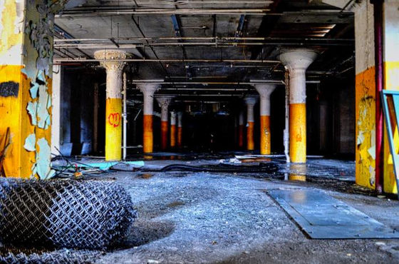 Yellow and orange columns receding through a dark abandoned interior.