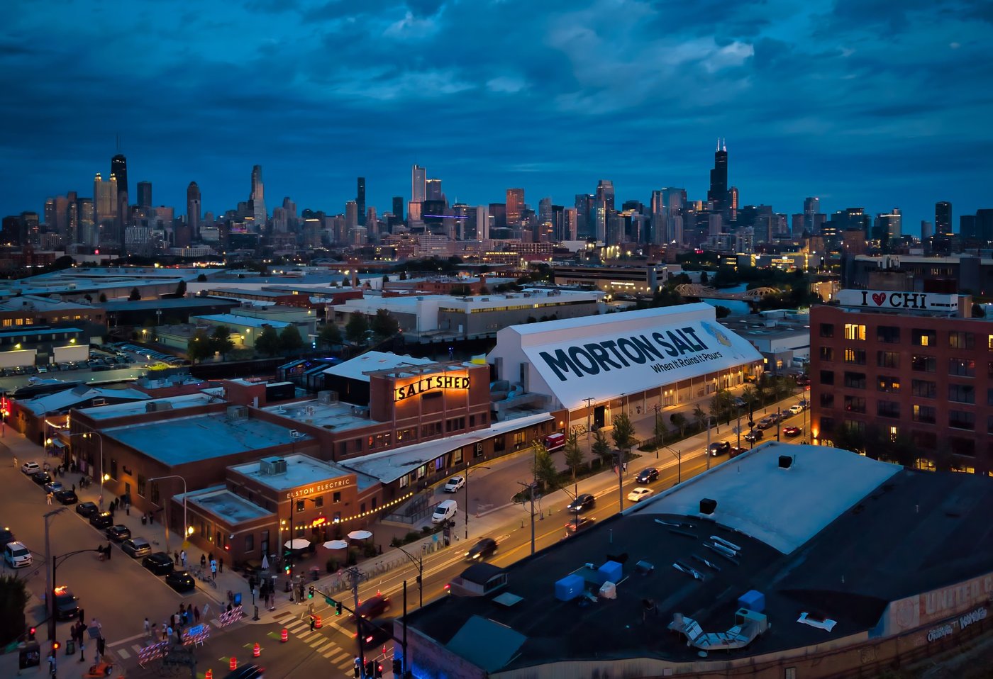 The Salt Shed at Blue Hour Chicago neighborhood rooftops and a Morton Salt roof sign beneath a cloudy dusk skyline.