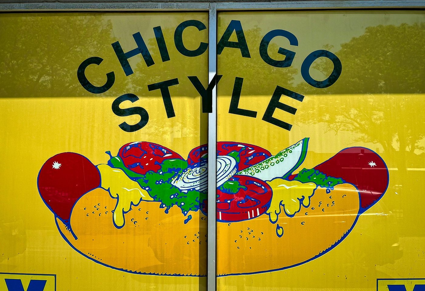 Chicago Classic Yellow Chicago-style hot dog sign painted across a window.