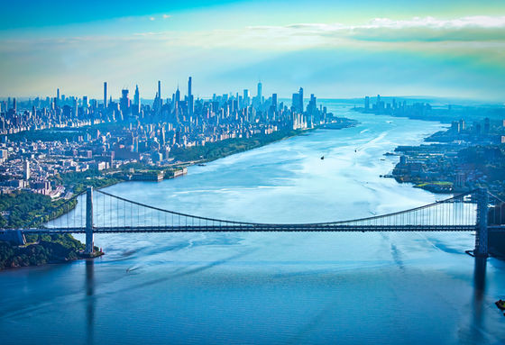 Aerial view of the George Washington Bridge across the Hudson River with Manhattan in the distance.