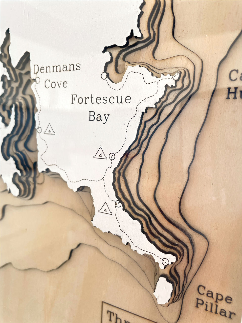 Angled close up of a Close up of the label of a 3D wooden topographic and bathymetric map of the Three Capes walk in Tasmania