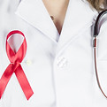 Woman doctor holding red ribbon HIV, wor