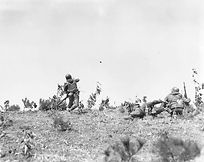 Korean conflict, 23 March 1951, platoon leader tosses a hand grenade in battle.