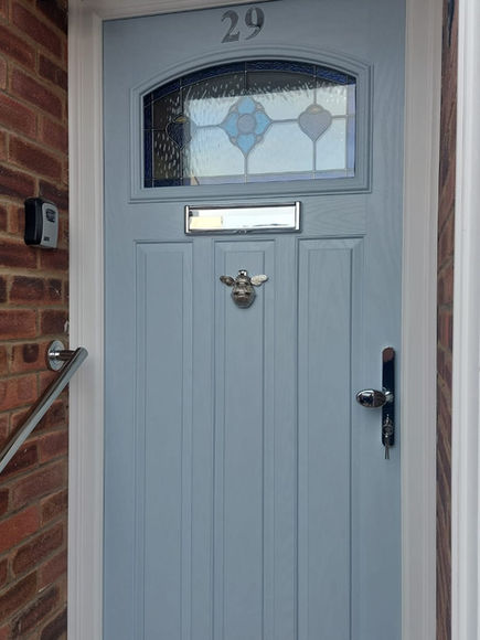 Light blue front door with letterbox and door knocker