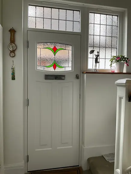 Internal view of white traditional front door with decorative stained glass panels
