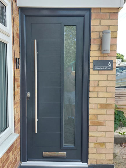Modern grey composite front door with long vertical handle
