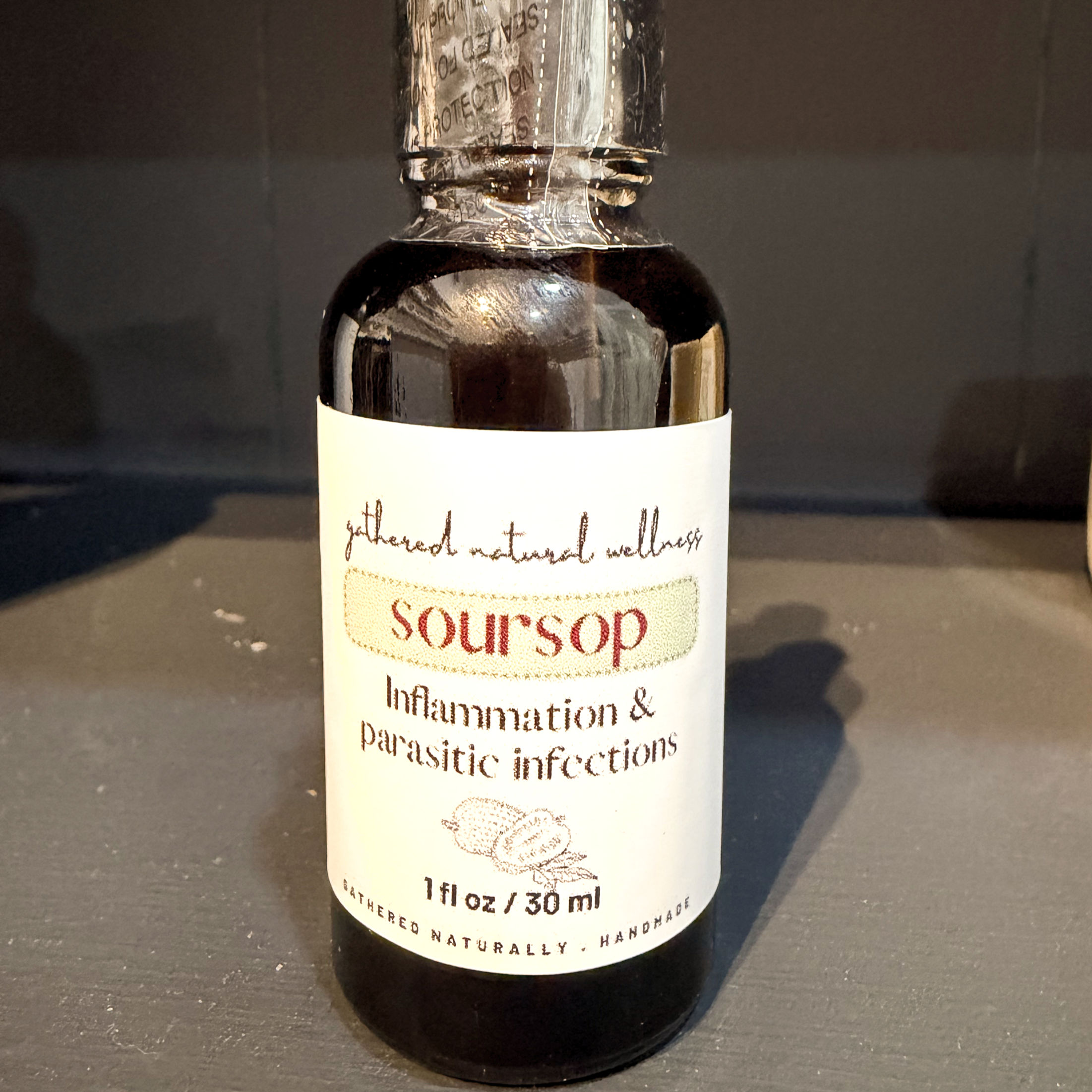 Amber bottle of Soursop Tincture on grey shelf