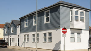 Image of terraced houses. The house are half grey and white with lots of windows
