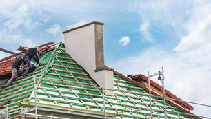 Roofers on a roof which is under construction